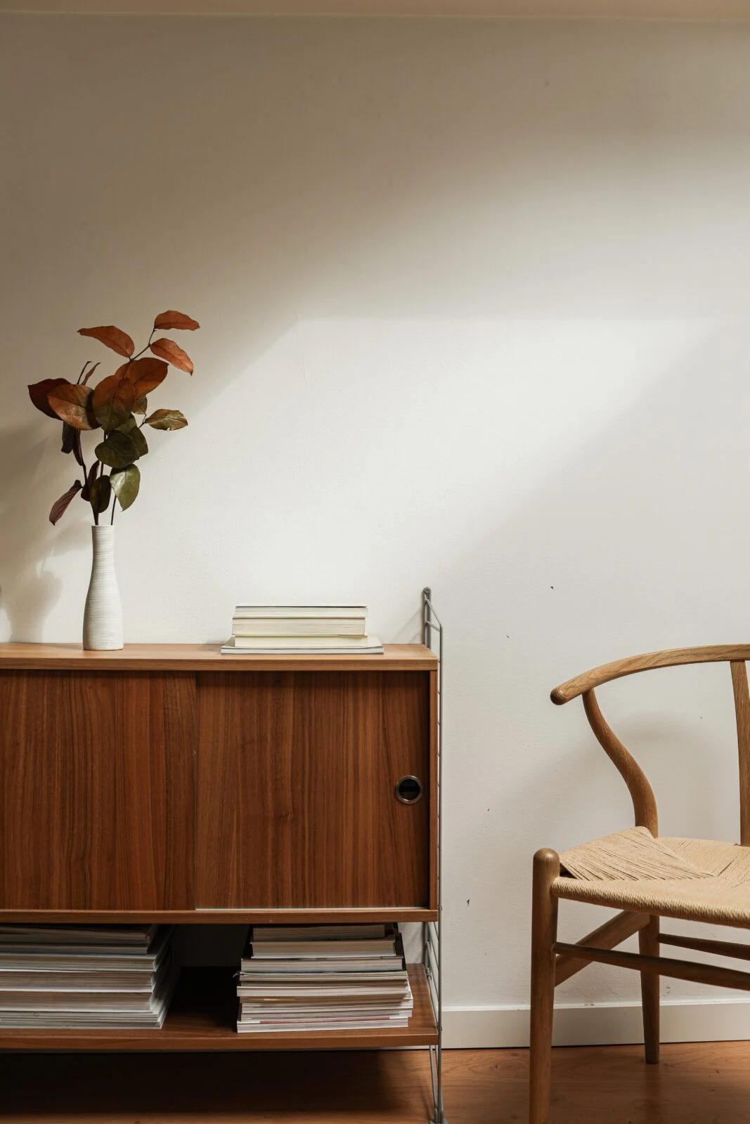 chair with a side table with book and a plant